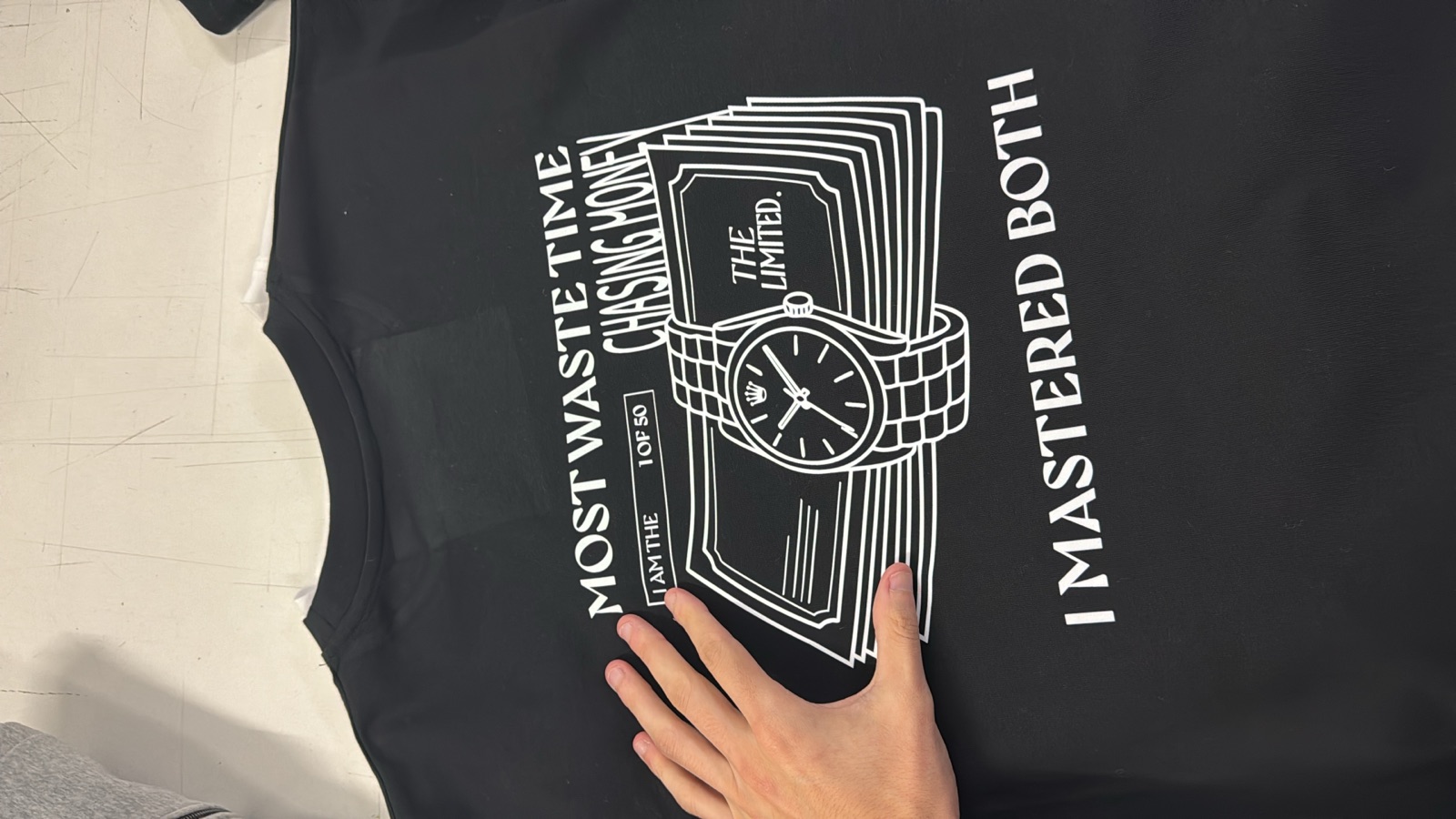 Black t-shirt with white screen-printed graphic of luxury watch and cash bundle for The Limited brand