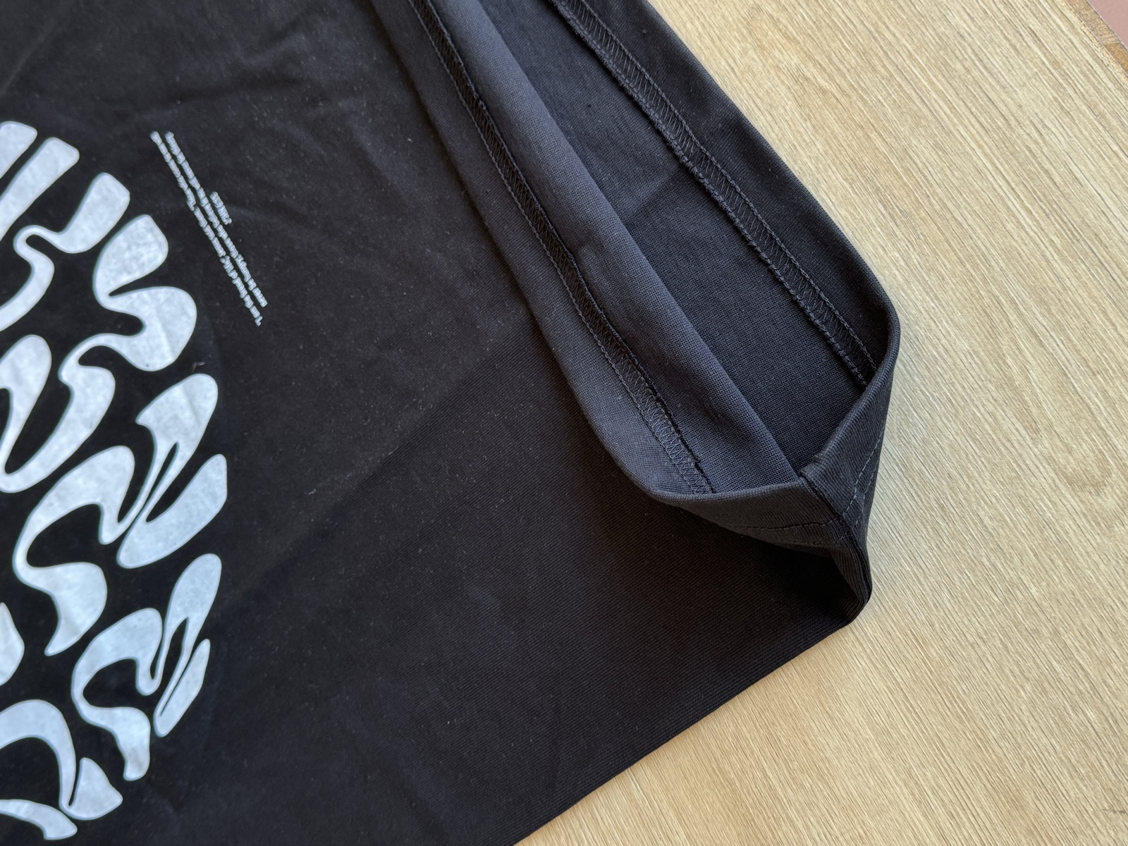 Black heavyweight hoodie on wooden hanger displaying grey Believe In Key24 printed graphic on the front