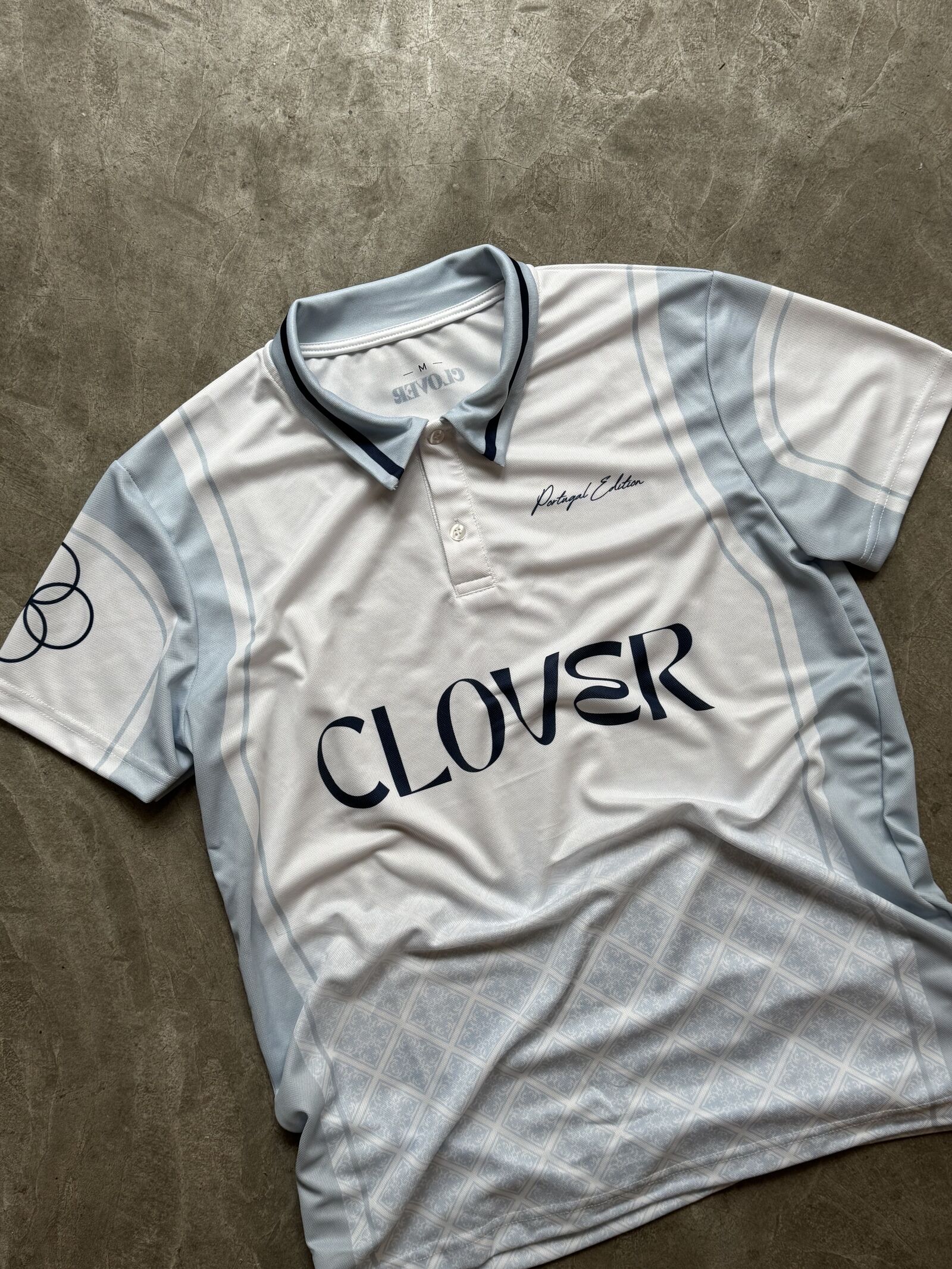 Light blue sublimated polo with Clover branding and azulejo panels
