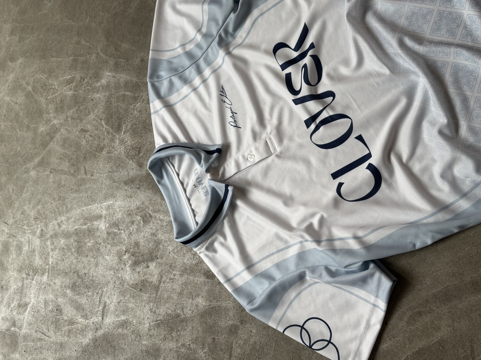 Light blue and white sublimation-printed sports jersey with Clover branding in navy lettering