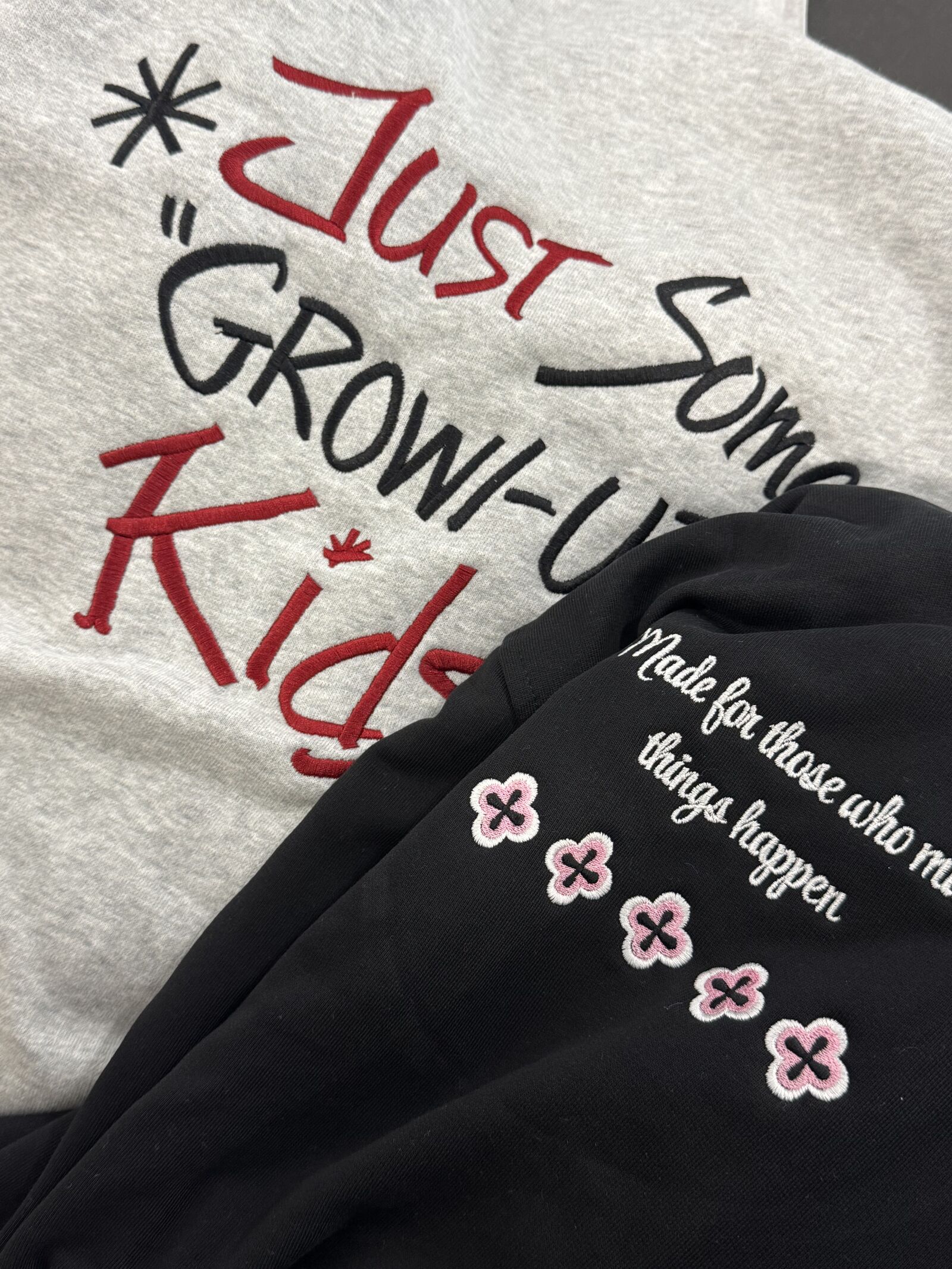 Two embroidered sweatshirts in heather grey and black with floral patches