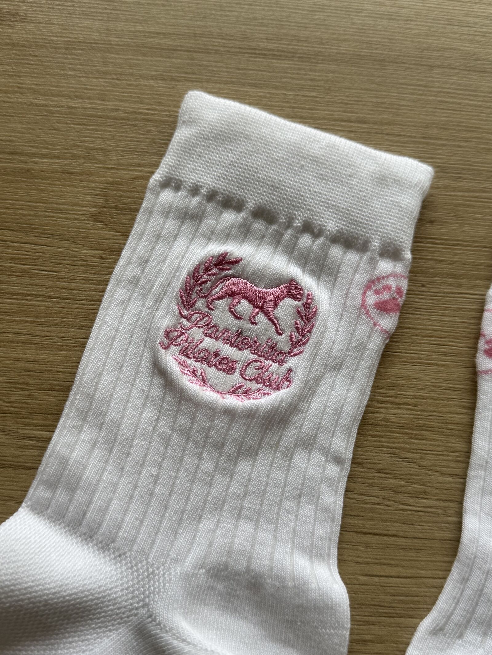 White ribbed socks with pink embroidered crest logo