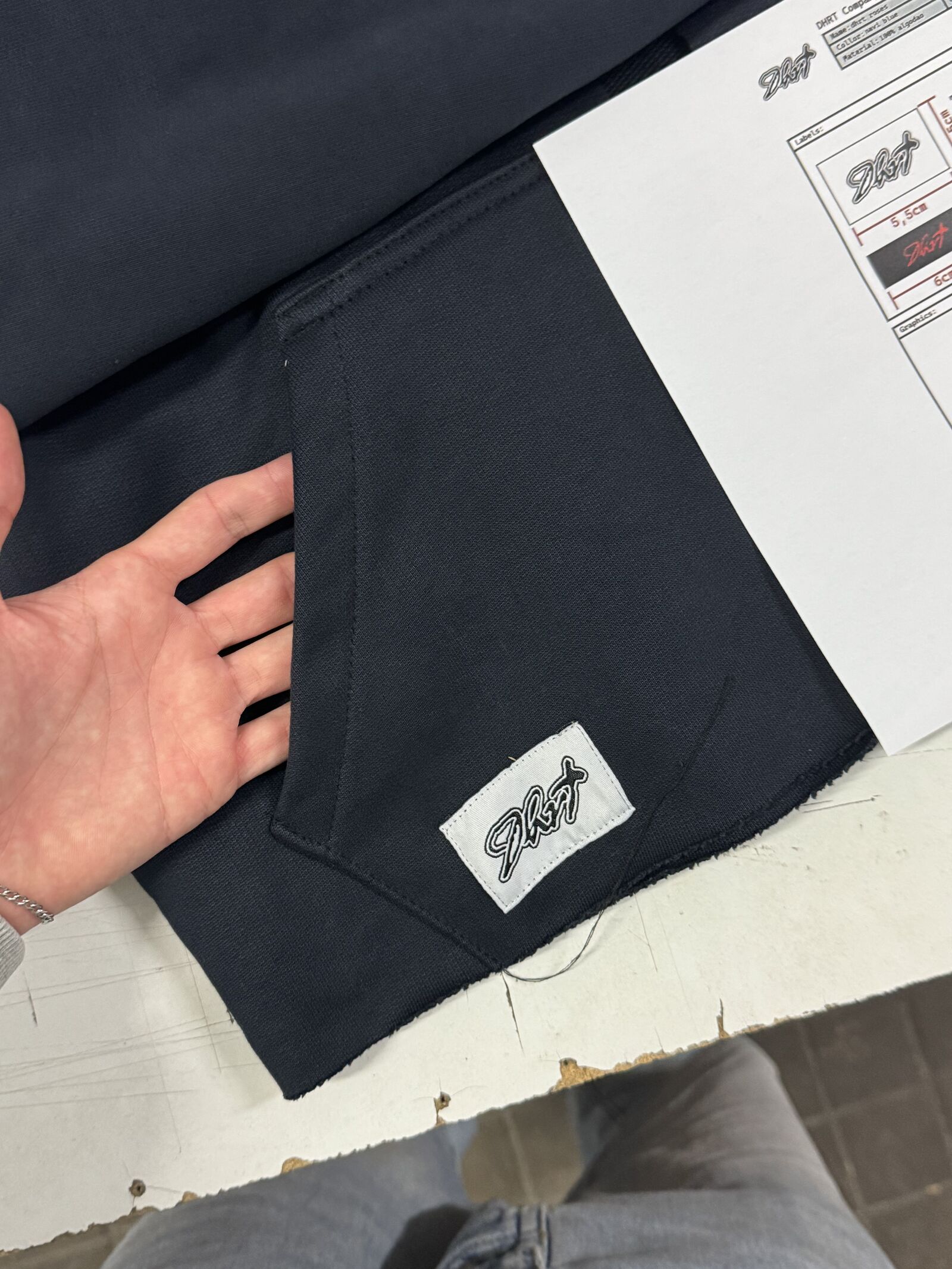 Worker inspecting fabric with technical spec sheet