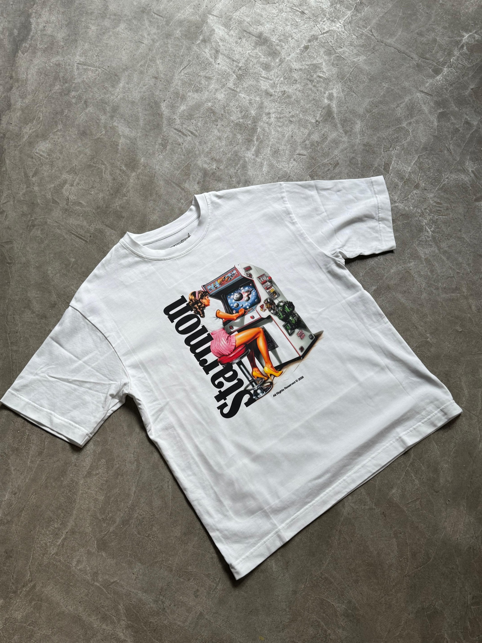 White oversized t-shirt with colorful collage illustration and Stepmon bold typography on the back
